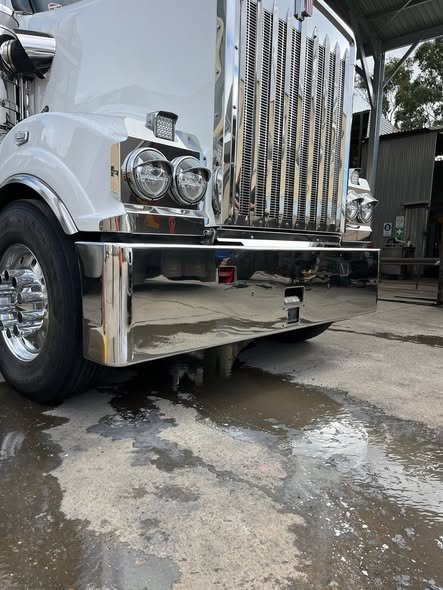 Close-up of a polished Kenworth front end and alloy rim